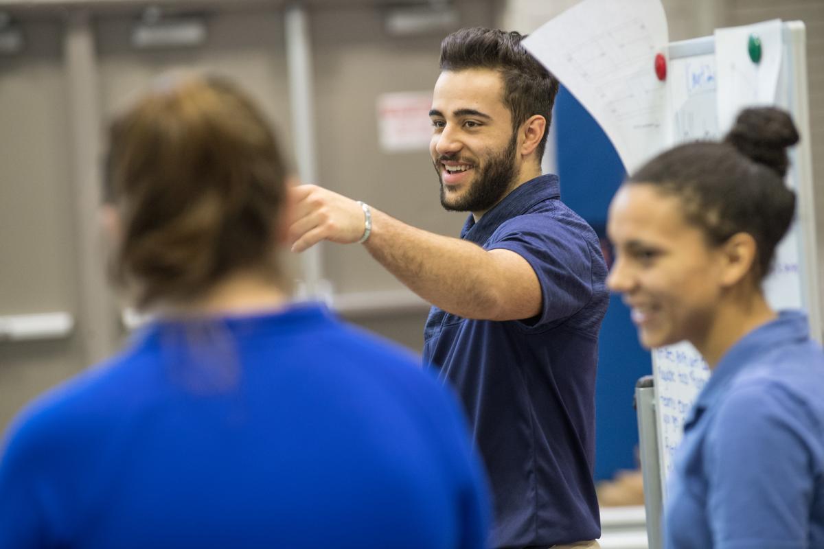 Athletic training faculty member wearing blue polo shirt in gym