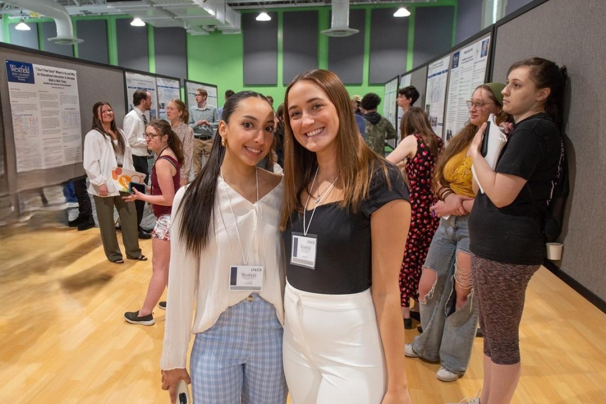 Two marketing students smiling at undergraduate research event.