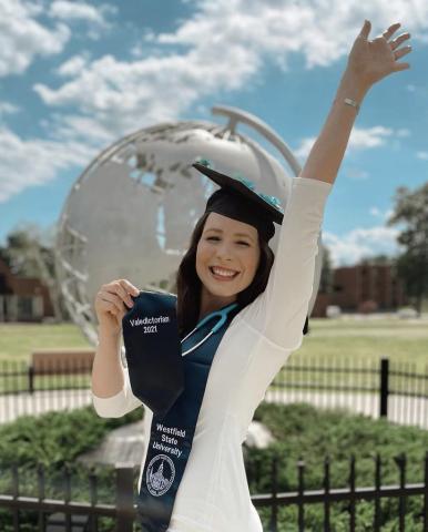 Photo of Hannah Griswold, WSU 2021 Valedictorian in front of the Globe sculpture on the campus green
