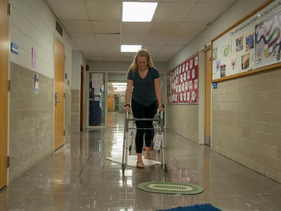 A Health Sciences student negotiates obstacles with a walker