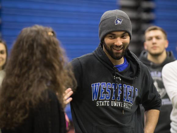 Movement science student wearing WSU sweatshirt and hat with the WSU owl logo.