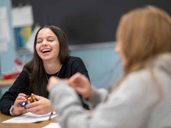 Student smiling holding rubik's cube in Math Tutoring Center.