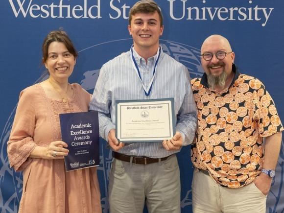 Communication student smiling with faculty at Academic Awards Ceremony.