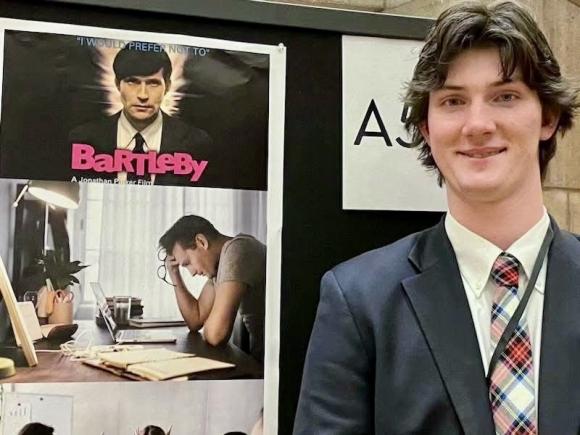 English student smiling giving a presentation.