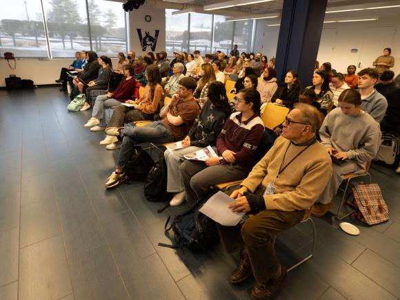 Crowd of people sit in a lecture