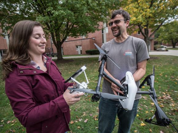 Urban and Regional Planning student and faculty member holding scientific equipment.