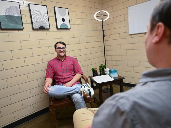 Counseling student attentively listening during a mock session with another student.