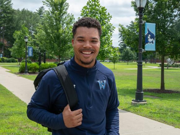 Student smiling while outside on the campus green.