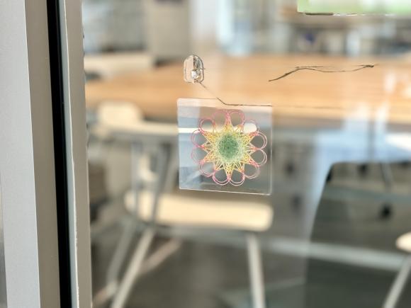 Window showcasing a geometrical pattern created in a math explorations class.