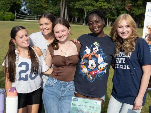 Students look at camera at Club Fair