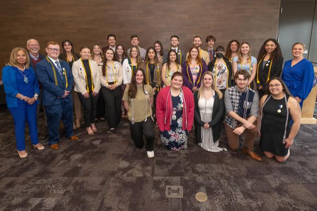 Group photo from the Honors Symposium including students and faculty smiling.