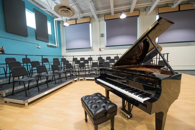 Dower Center classroom with a piano and chairs.