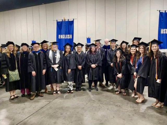 English students wearing caps and gowns at commencement.