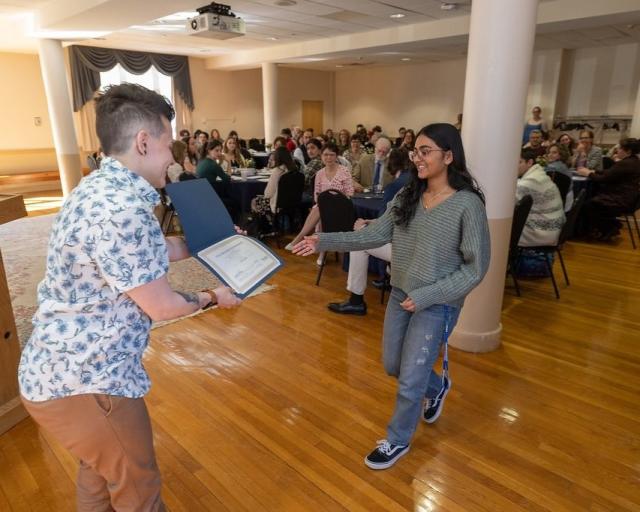 Student receiving an award at the English Spring Gathering event.