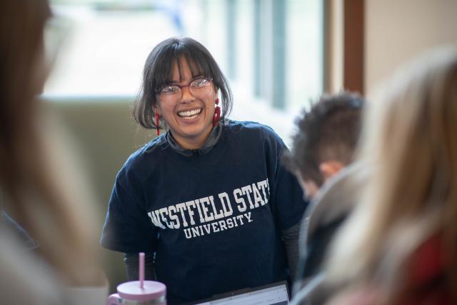 Student smiling on campus while wearing a Westfield State University shirt.