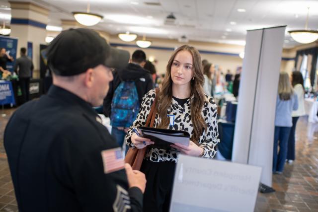 Student talking to an employer at a job and career fair.