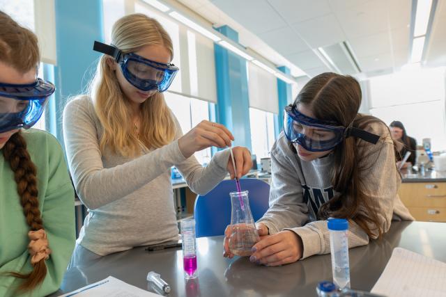 Students conducting an experiment with vials in a chemistry lab.