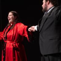 A women in a red robe singing on stage next to her co-star in a suit, as part of The Bat’s Revenge, a lively operetta based on Johann Strauss II's Die Fledermaus, with a fresh, modern twist set in 1930s Hollywood. 